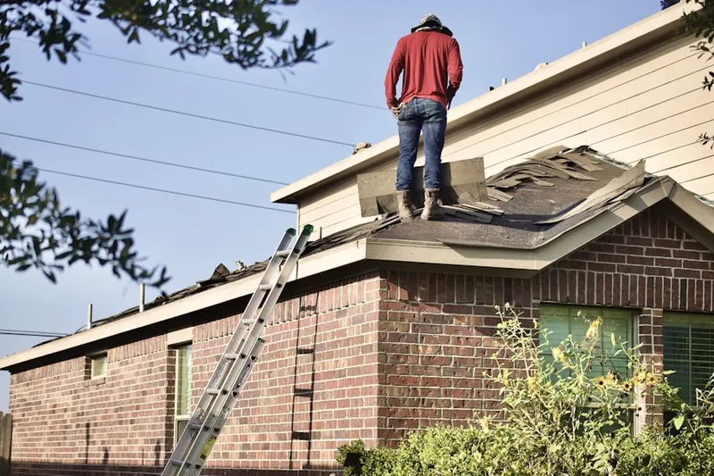 Professional roofer working on a residential roof in Eudora